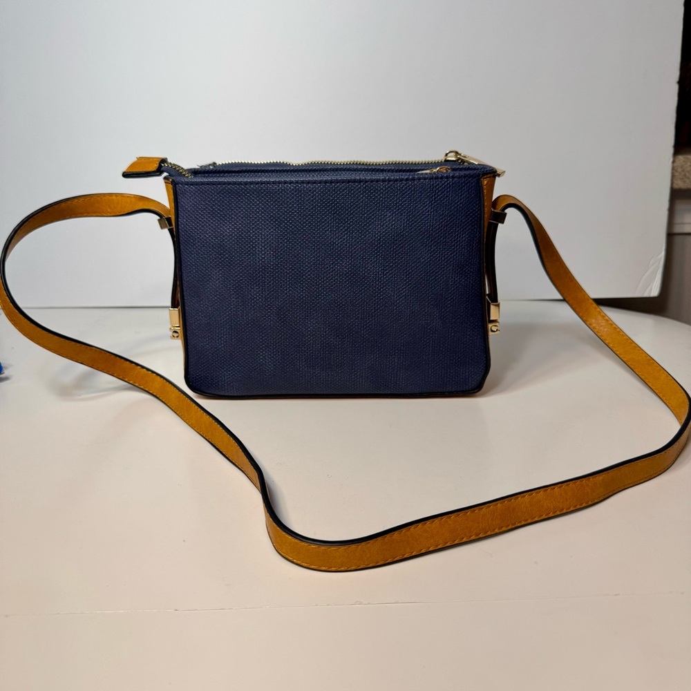 Pre-owned small crossbody bag. No brand listed. Navy blue with yellow-tan straps